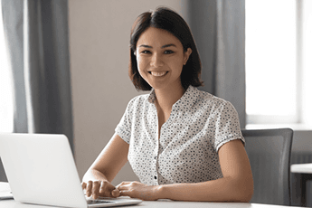 Person smiling at a laptop ready to get started reducing student loan debt