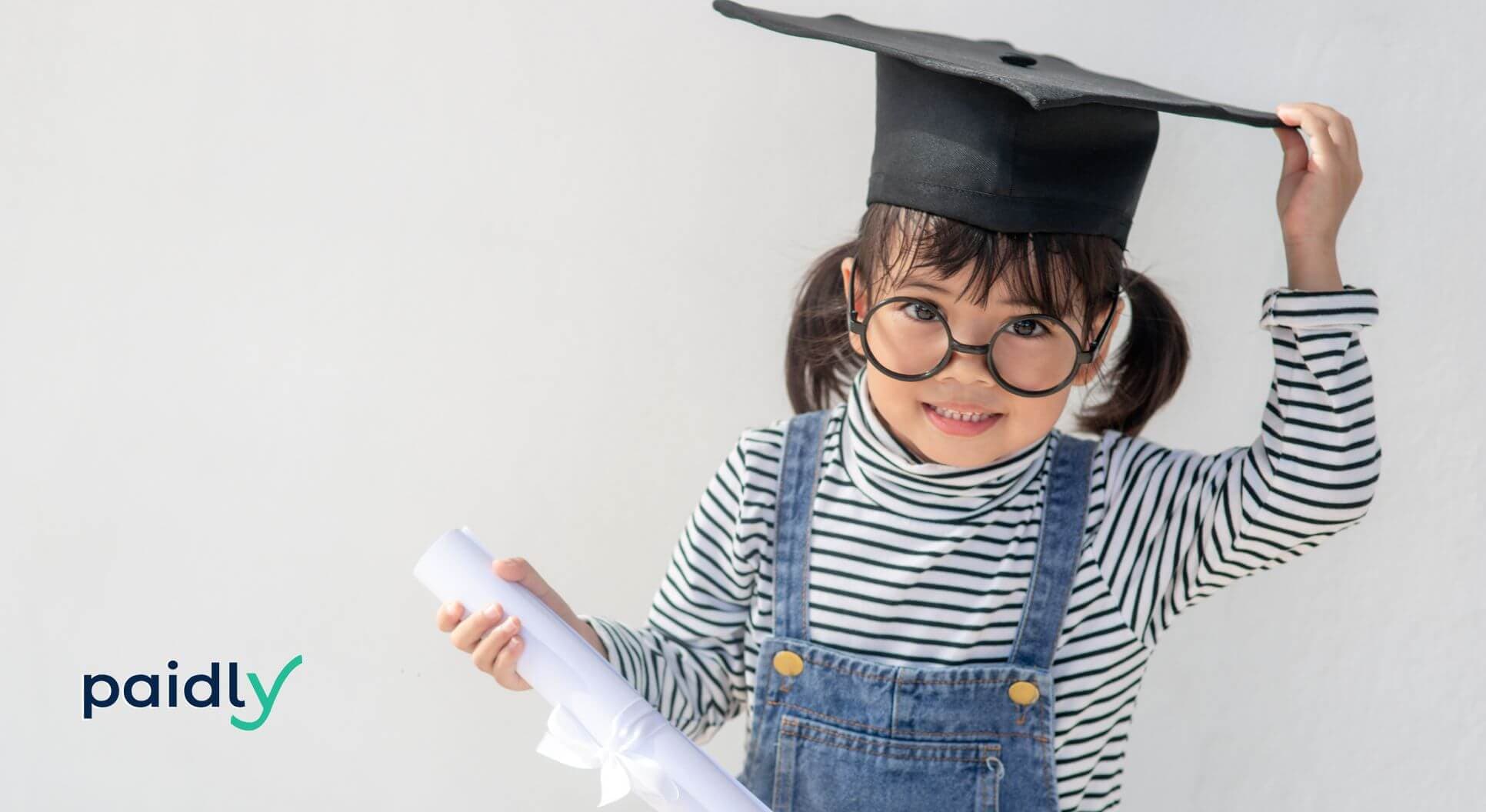 Child in a graduation cap holding a diploma 