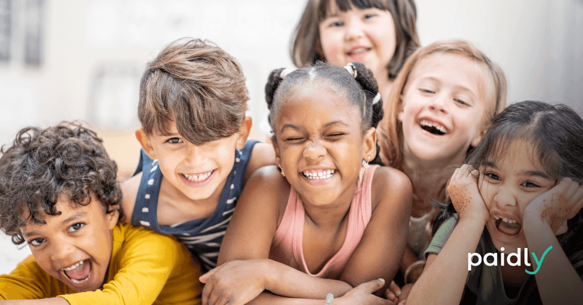 Group of children laughing with the Paidly logo