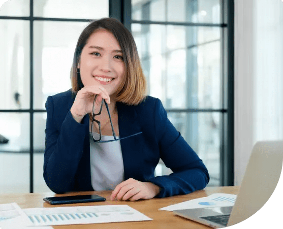 An HR manager smiling and working on a laptop, illustrating easy integration of Paidly.