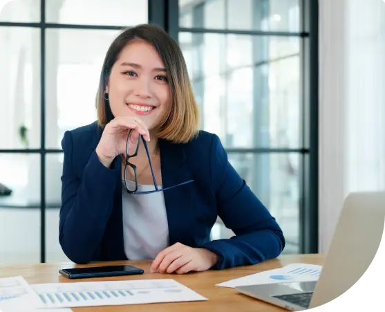 An HR manager smiling and working on a laptop, illustrating easy integration of Paidly.